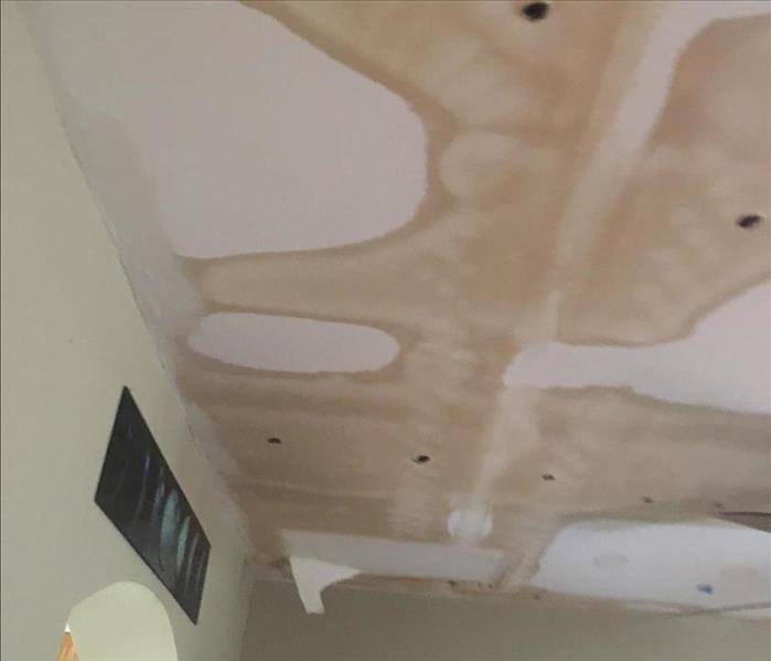 brown water stains on white ceiling from shower leaking above